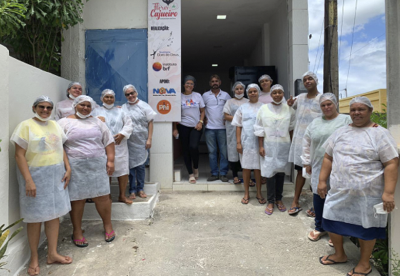 Foto de um grupo de pessoas participantes da Panificadora Cajueiro em frente ao Instituto Dom de Deus.