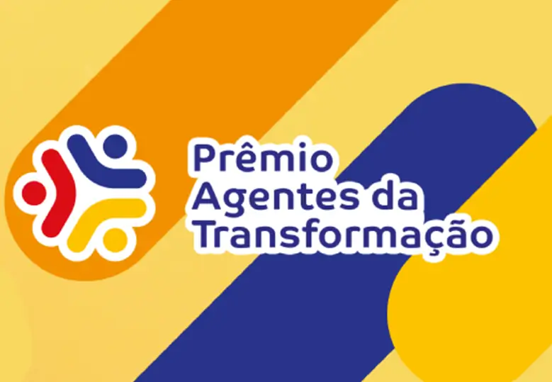 Arte em fundo amarelo com linhas paralelas nas cores laranja, azul e amarelo. À esquerda há o ícone de três pessoas formando um círculo e o texto "Prêmio Agentes da Transformação".