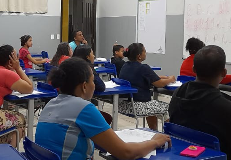 Foto de um grupo diverso de estudantes sentados em uma sala de aula.